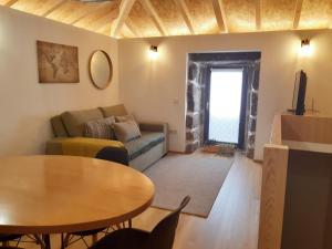 a living room with a couch and a table at VillaGarcia-Casa da Peneira in Terras de Bouro
