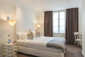 een hotelkamer met een bed en een raam bij Hotel Le Placide Saint-Germain Des Prés in Parijs