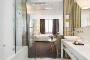 a bathroom with a shower and a sink and a tub at Hotel Le Placide Saint-Germain Des Prés in Paris