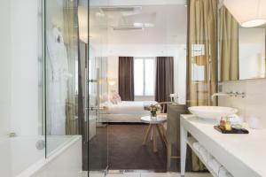 a bathroom with a shower and a sink and a tub at Hotel Le Placide Saint-Germain Des Prés in Paris +51 photos