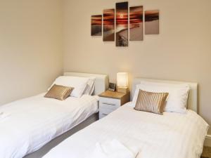 two beds in a room with white sheets at Dory in Sandown