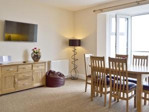 a dining room with a table and a tv on the wall at Dory in Sandown