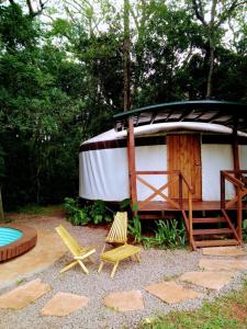 einen Pavillon mit zwei Stühlen und eine Terrasse mit Beihilfe in der Unterkunft Yurtas Ivirareta Glamping in Garupá
