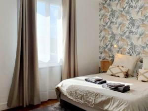Le Cosy Palm Tree by Madame Conciergerie في بروز: غرفة نوم عليها سرير وفوط