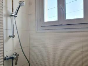 um chuveiro numa casa de banho ao lado de uma janela em Le Cosy Palm Tree by Madame Conciergerie em Bruz