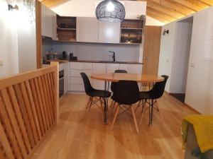 a kitchen with a table and chairs in a room at VillaGarcia-Casa da Peneira in Terras de Bouro