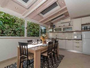 a kitchen with a wooden table and chairs at Cozy House in Seget Vranjica