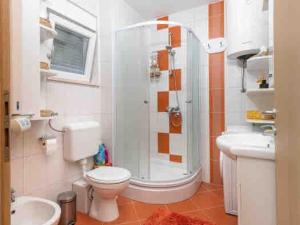a bathroom with a shower and a toilet and a sink at Cozy House in Seget Vranjica +19 photos