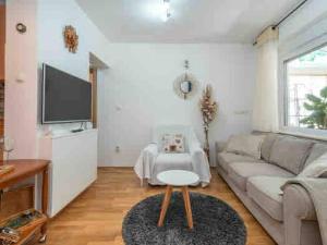 a living room with a couch and a tv at Cozy House in Seget Vranjica