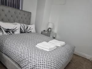 een slaapkamer met een bed met twee handdoeken erop bij Quantock Lodge Vicarage 1 in Rochester