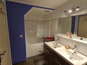 a bathroom with two sinks and a large mirror at Les Balcons de l'Eterlou in Les Deux Alpes