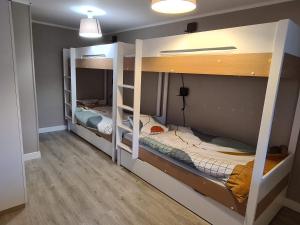2 łóżka piętrowe w pokoju z drewnianą podłogą w obiekcie Les Balcons de l'Eterlou w mieście Les Deux Alpes