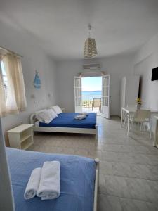 sypialnia z niebieskim łóżkiem oraz stołem i krzesłami w obiekcie Kleanthi Apartments w mieście Drios