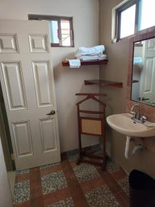 La salle de bains est pourvue d'une porte blanche et d'un lavabo. dans l'établissement Casa DOTO, à Ciudad Sahagún