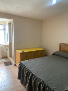 - une chambre avec un lit et une commode en bois dans l'établissement Casa DOTO, à Ciudad Sahagún