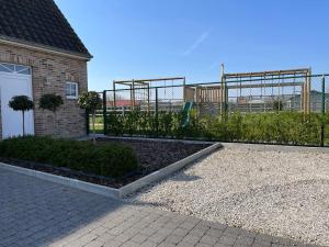 a backyard with a fence and a playground at Huis Marlin in De Haan