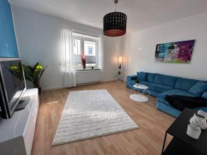 - un salon avec un canapé bleu et un tapis blanc dans l'établissement Dream Living 1 im Essener Süden, à Essen