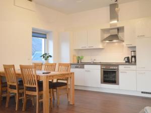 a kitchen and dining room with a wooden table and chairs at Lovely modern apartment with private terrace in Ellscheid