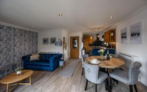 a living room with a table and a blue couch at Canalside Apartment in Fort William