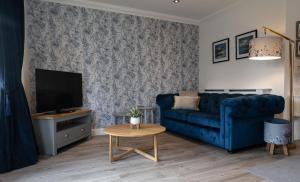 a living room with a blue couch and a tv at Canalside Apartment in Fort William