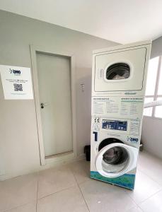uma máquina de lavar roupa num quarto ao lado de uma porta em Home Time Studios em Florianópolis