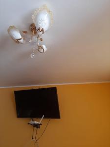 een plafond met een kroonluchter en een tv in een kamer bij Casa La Ruta Pisco in Pisco