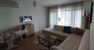 sala de estar con sofá y TV en 3+1 COZY SUMMER APARTMENT WITH PRIVATE BEACH, en Side