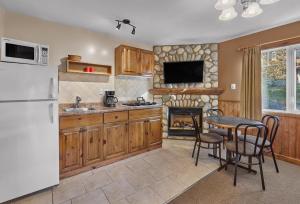 a kitchen with a refrigerator and a table and a fireplace at Patricia Lake Bungalows in Jasper