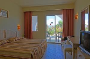 a hotel room with two beds and a television at Hotel Meninx Djerba in Triffa