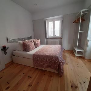 um quarto com uma cama e piso em madeira em Casa da Esquina - Sintra em Sintra