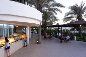 ein Restaurant mit Tischen auf einer Terrasse in der Unterkunft Hotel Meninx Djerba in Triffa