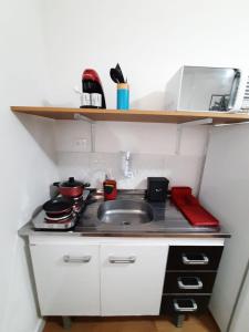 cocina pequeña con fregadero y fogones en Studio Liberdade Paulista DB2, en São Paulo