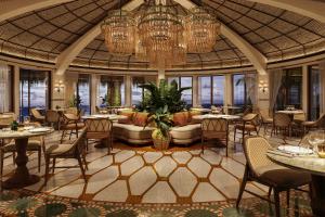 a restaurant with tables and chairs and a chandelier at Maroma, A Belmond Hotel, Riviera Maya in Puerto Morelos