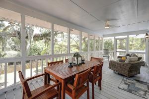 a dining room with a table and chairs and windows at C Turtle in Edisto Island