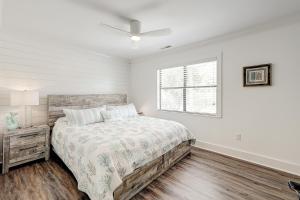 a white bedroom with a bed and a window at C Turtle in Edisto Island