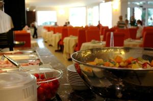 a table with a bowl of food on a table at Hotel Capri Bardolino 3S in Bardolino