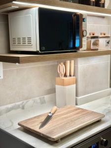 a knife on a cutting board next to a microwave at Apartamentos Noja Playa in Noja