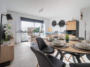 uma sala de jantar e sala de estar com mesa e cadeiras em CASCADA del MAR II - GRAN ALACANT em Gran Alacant