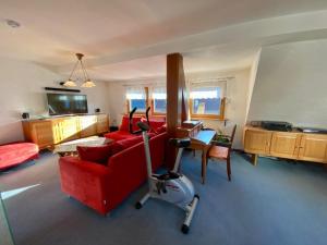 a living room with a red couch and a vacuum at Cozy villa with garden, balcony and parking area in Düsseldorf in Düsseldorf