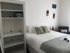una camera con letto bianco e scaffali di Casa Prana a Bragança Paulista