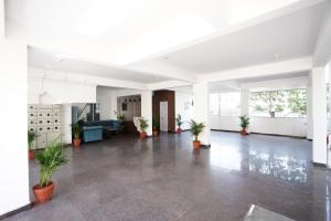 an empty lobby with potted plants in a building at Castle Suites by Haven Homes, Kempegowda International Airport road in Bangalore