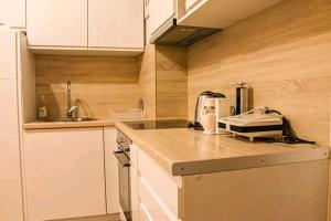 a kitchen with white cabinets and a counter top at Apartman Lada in Bijeljina