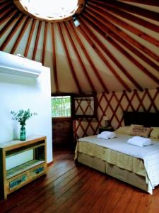 a room with a bed and a tv in a yurt at Yurtas Ivirareta Glamping in Garupá