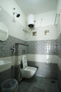 a bathroom with a toilet and a sink at Castle Suites by Haven Homes, Kempegowda International Airport road in Bangalore