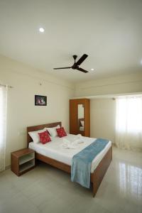 バンガロールにあるCastle Suites by Haven Homes, Kempegowda International Airport roadの天井ファン付きの大きなベッドのある寝室