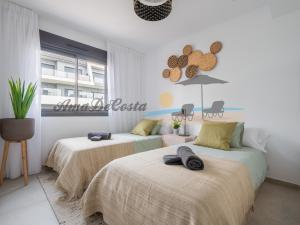 2 camas en una habitación con paredes blancas en CASCADA del MAR II - GRAN ALACANT, en Gran Alacant