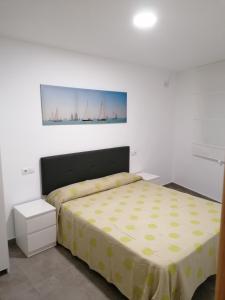 1 dormitorio con 1 cama con colcha amarilla en Alojamiento Las Dunas Bajo, en Tabernas