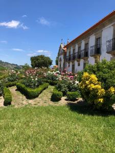 un jardín con flores y arbustos frente a un edificio en Casa da Agrela, en Ponte da Barca