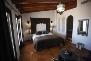 a bedroom with a bed and a table in a room at La Posada del Torcal in Villanueva de la Concepción