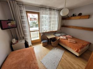 a bedroom with a bed and a tv and a window at Willa Helena in Zakopane